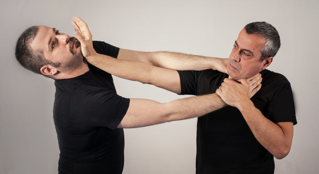 
Kapap instructor demonstrates street fighting self defense technique against holds and grabs with his student